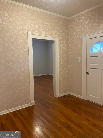 a view of empty room with wooden floor and fireplace