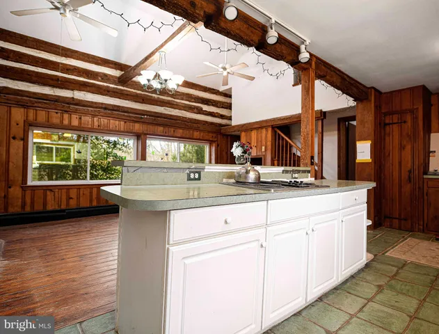 an empty room with wooden floor fireplace and windows