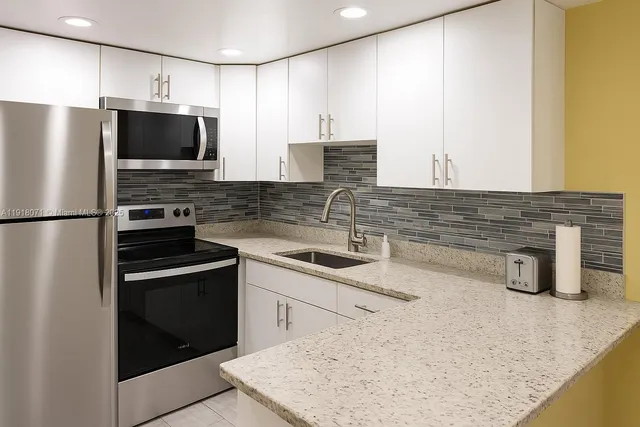 a kitchen with stainless steel appliances granite countertop a sink stove and refrigerator