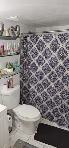 a bathroom with a toilet and a shower curtain
