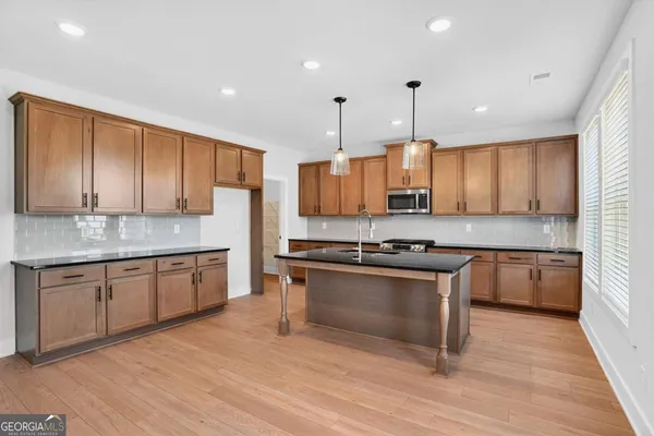 a kitchen with granite countertop wooden cabinets stainless steel appliances and a counter space