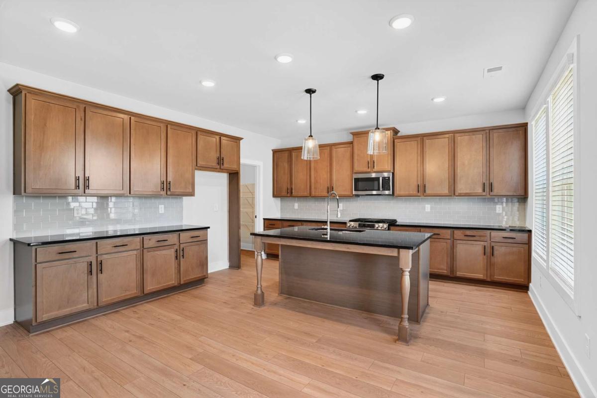 613 Villa Rica Springs Villa Rica, GA 30180 - Photo 18 of 40 a kitchen with granite countertop wooden cabinets stainless steel appliances and a counter space