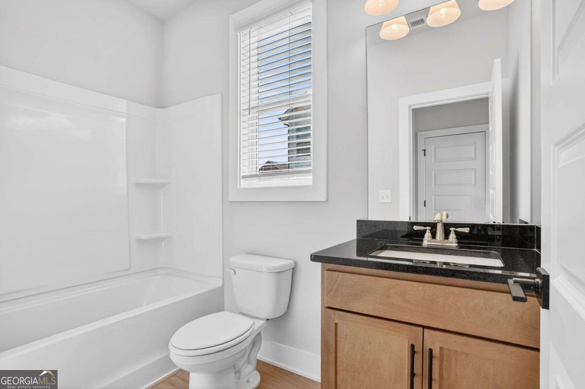 613 Villa Rica Springs Villa Rica, GA 30180 - Photo 21 of 40 a bathroom with a granite countertop sink a toilet a mirror and shower