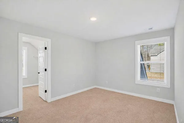 an empty room with windows and closet