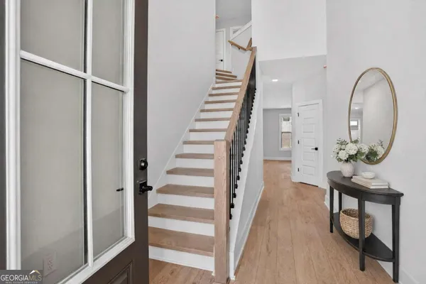 a view of a hallway with wooden floor and entryway