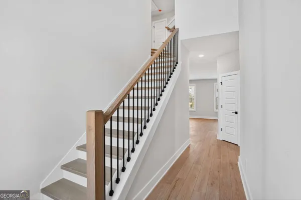 a view of a hallway with wooden floor and staircase