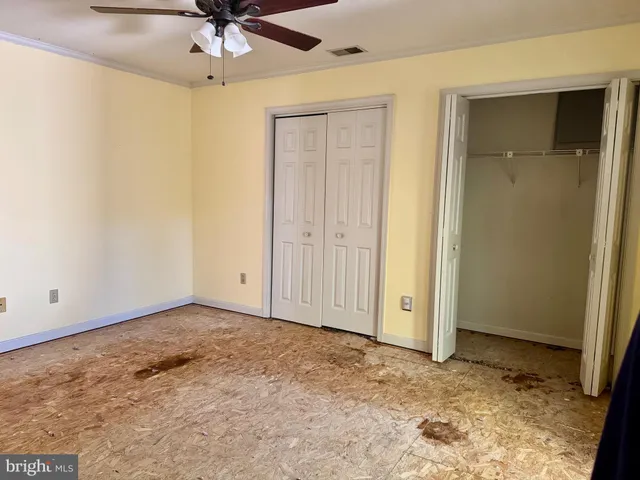 an empty room with a ceiling fan and a window