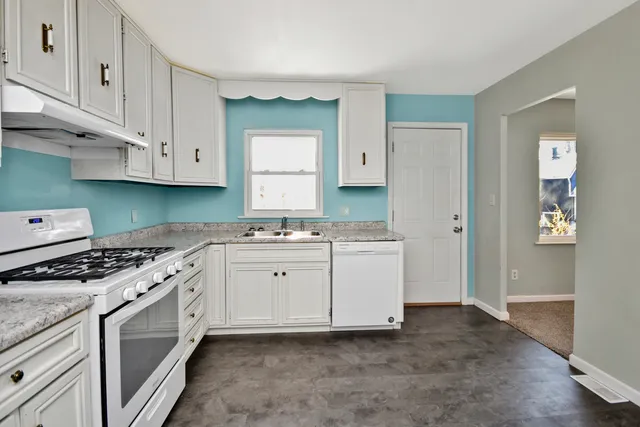 a kitchen with granite countertop a sink and a stove