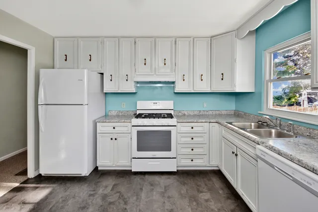 a kitchen with white cabinets and white appliances
