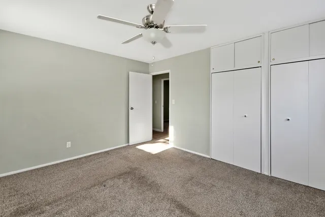 a view of an empty room with a ceiling fan