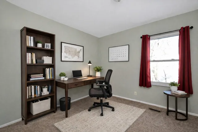 a view of a workspace with a window and a bookshelf