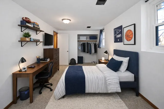 a bedroom with a bed and a desk