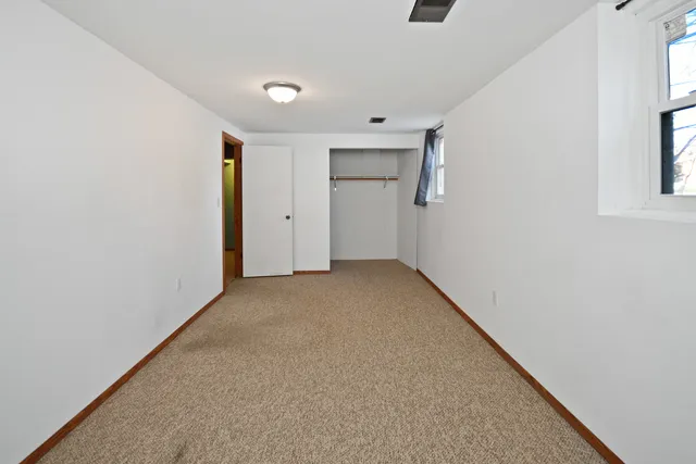a view of a big room with closet and windows