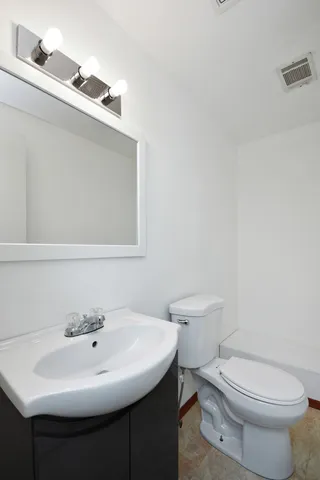 a bathroom with a sink a toilet and mirror