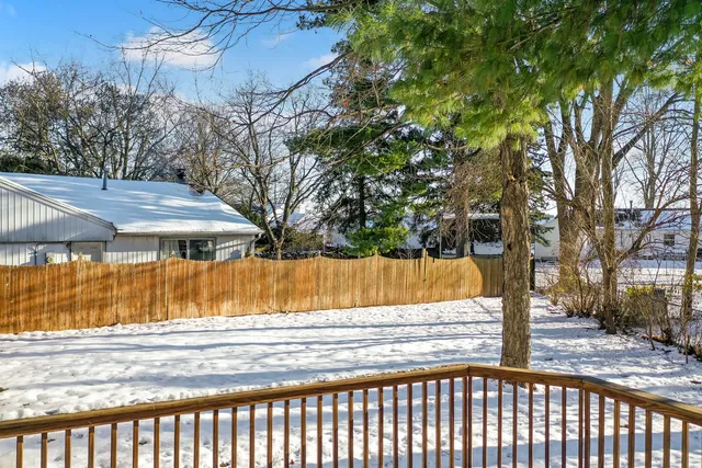 a view of backyard with small cabin and wooden fence