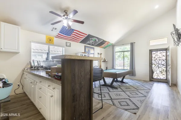 a kitchen with stainless steel appliances granite countertop a stove a sink dishwasher and a dining table with cabinets