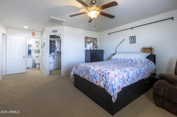 a spacious bedroom with a bed and a chandelier