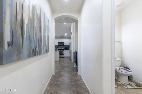 a view of a hallway with wooden floor and a bathroom