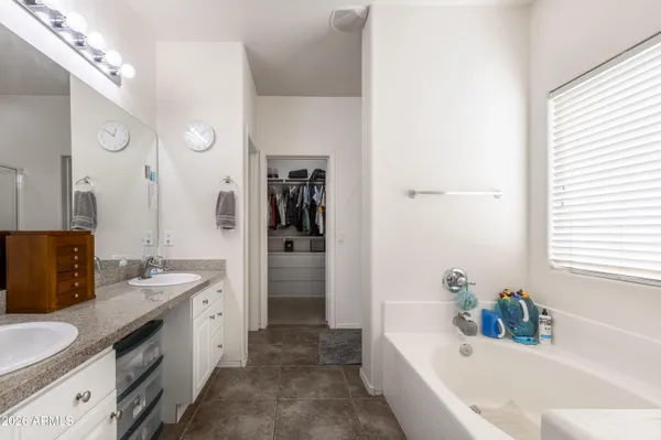 a bathroom with a granite countertop tub sink double vanity granite tub shower and mirror