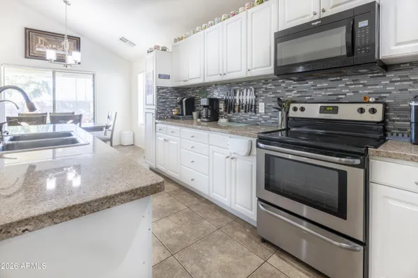 a kitchen with stainless steel appliances granite countertop a stove microwave and sink