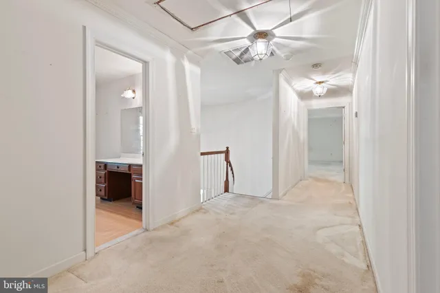 a view of a big room with chandelier fan and a bathroom