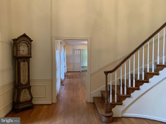 a view of a hallway with wooden floor and staircase