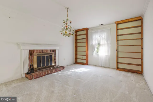 an empty room with a fireplace and cabinet