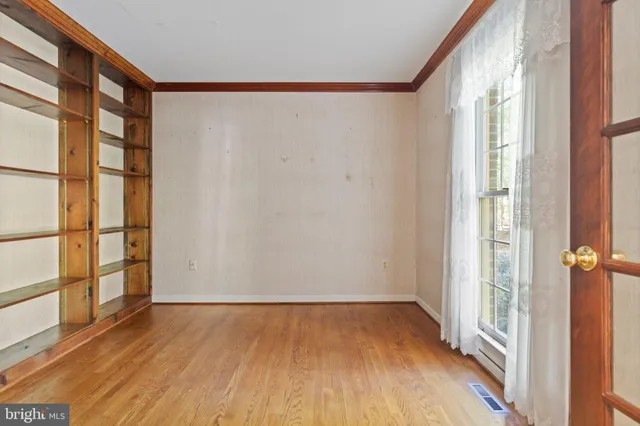 a view of a big room with wooden floor and windows