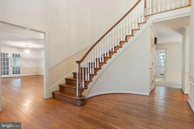 a view of staircase with wooden floor and a chandelier