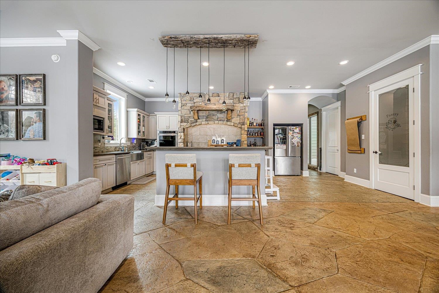 897 Burrowtown Road Mason, TN 38049 - Photo 36 of 36 Kitchen featuring stone tile floors, dark countertops, open floor plan, arched walkways, and crown molding