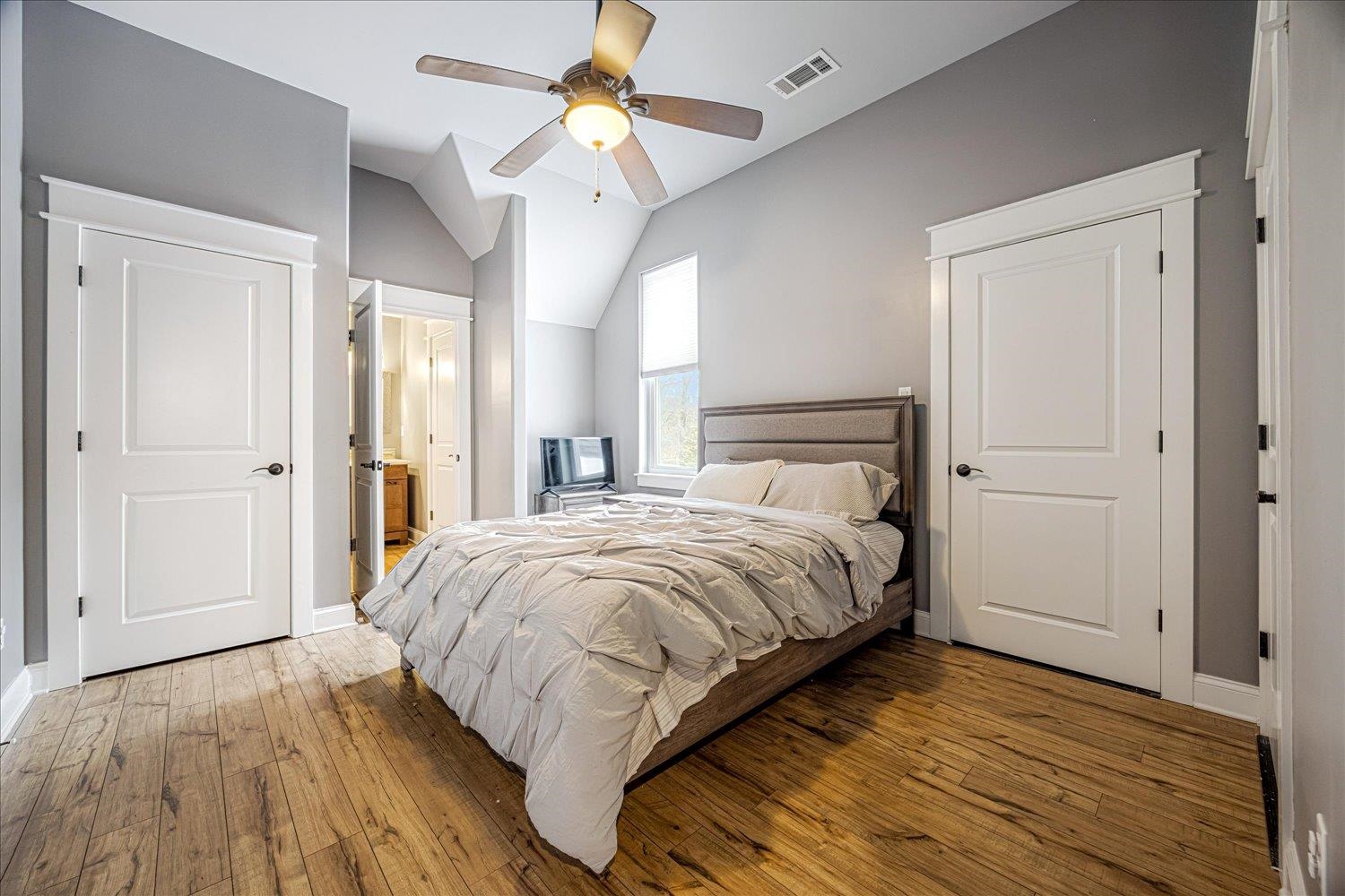 897 Burrowtown Road Mason, TN 38049 - Photo 18 of 36 Bedroom with ensuite bathroom, light wood-style floors, vaulted ceiling, and a ceiling fan