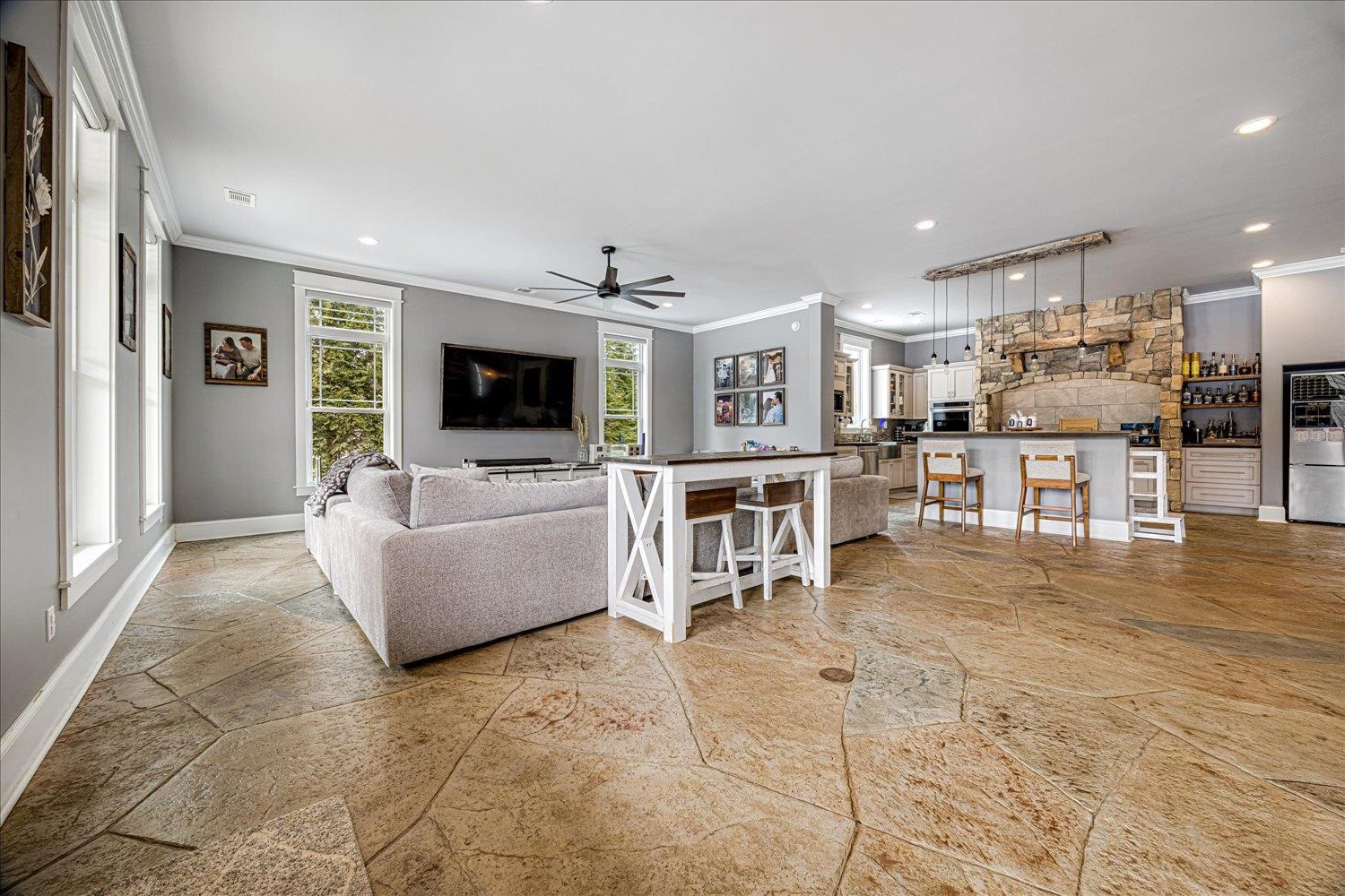 897 Burrowtown Road Mason, TN 38049 - Photo 5 of 36 Living room with crown molding, ceiling fan, recessed lighting, and light stone finish floors