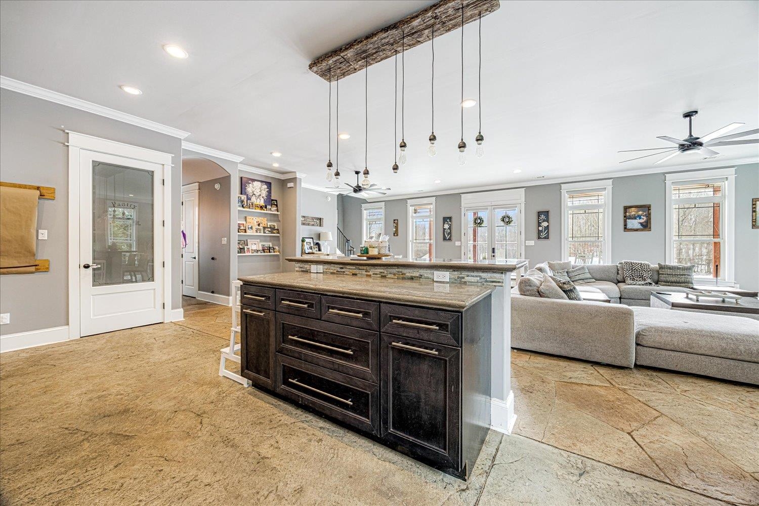 897 Burrowtown Road Mason, TN 38049 - Photo 35 of 36 Kitchen with pendant lighting, a ceiling fan, light stone counters, ornamental molding, and open floor plan