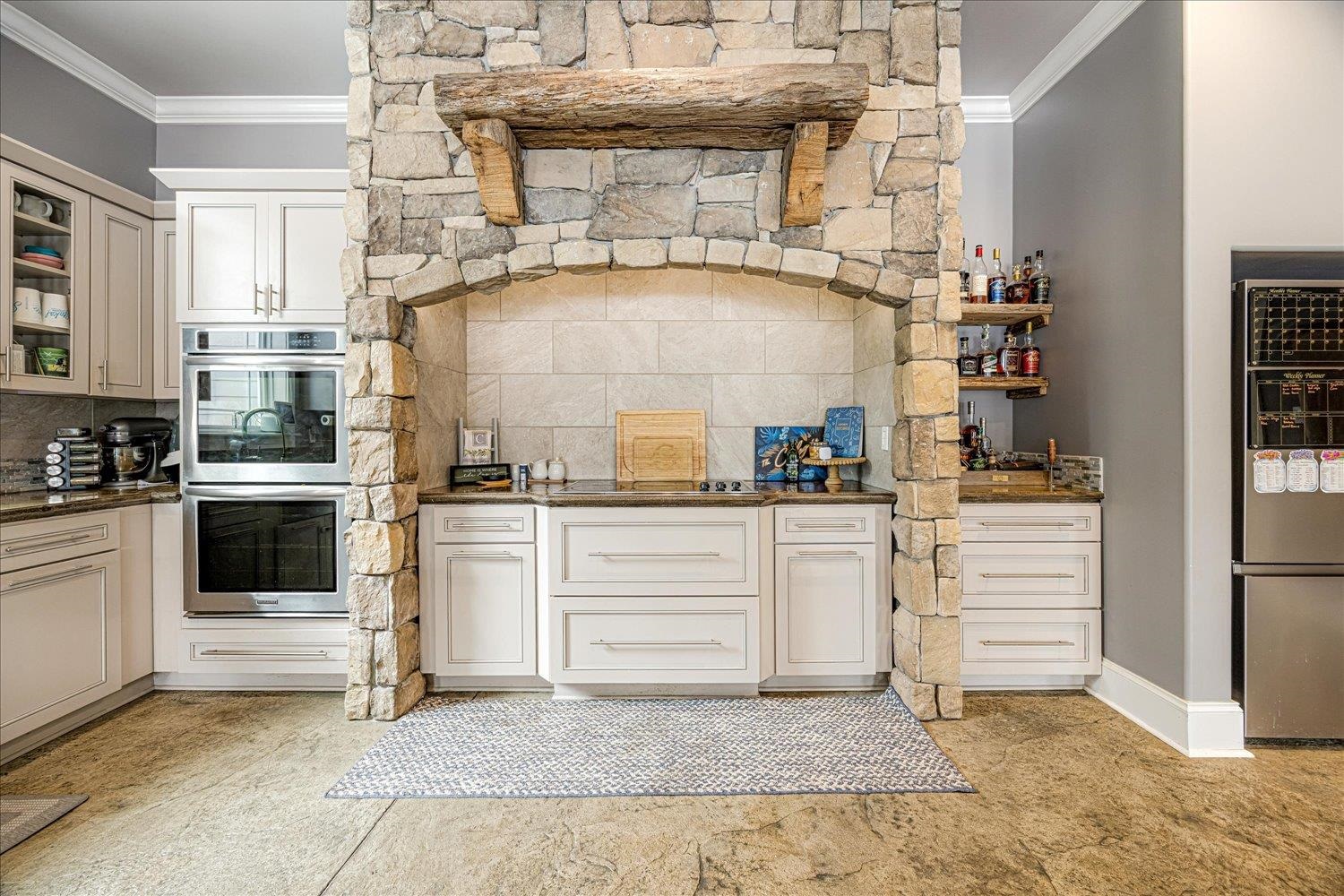 897 Burrowtown Road Mason, TN 38049 - Photo 9 of 36 Kitchen with crown molding, stainless steel appliances, glass fronted cabinets, dark stone counters, and white cabinets