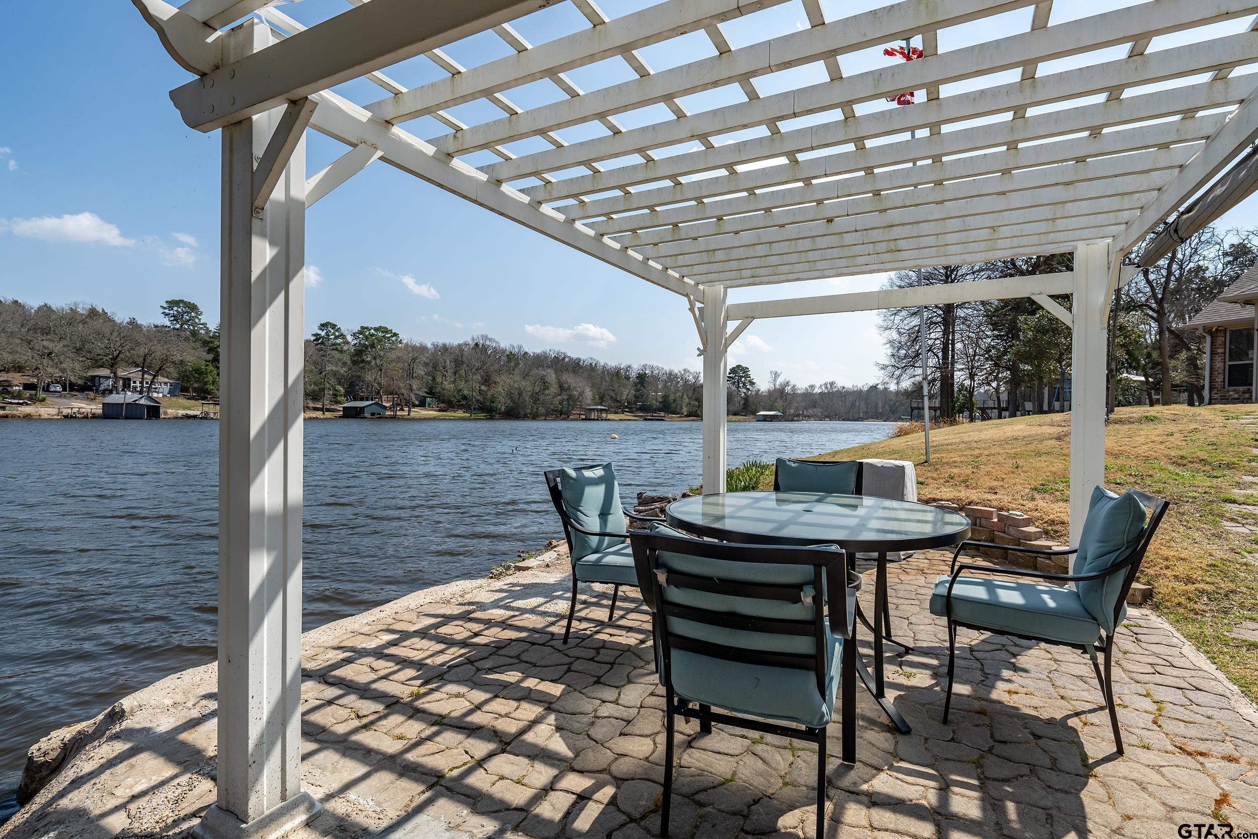 a backyard view of a house with lake outdoor seating and barbeque oven