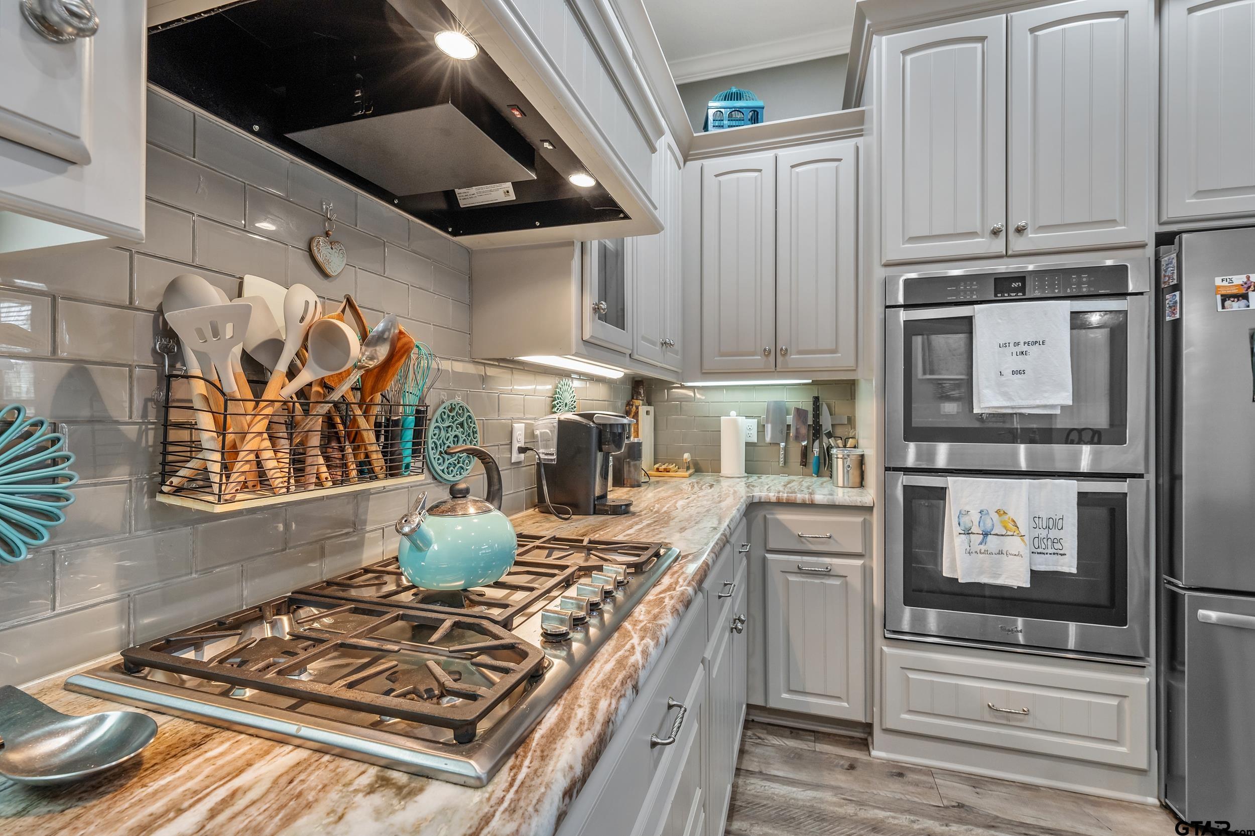 10918 Spring Club Lake Tyler, TX 75706 - Photo 18 of 23 a kitchen with stainless steel appliances granite countertop a stove and a refrigerator