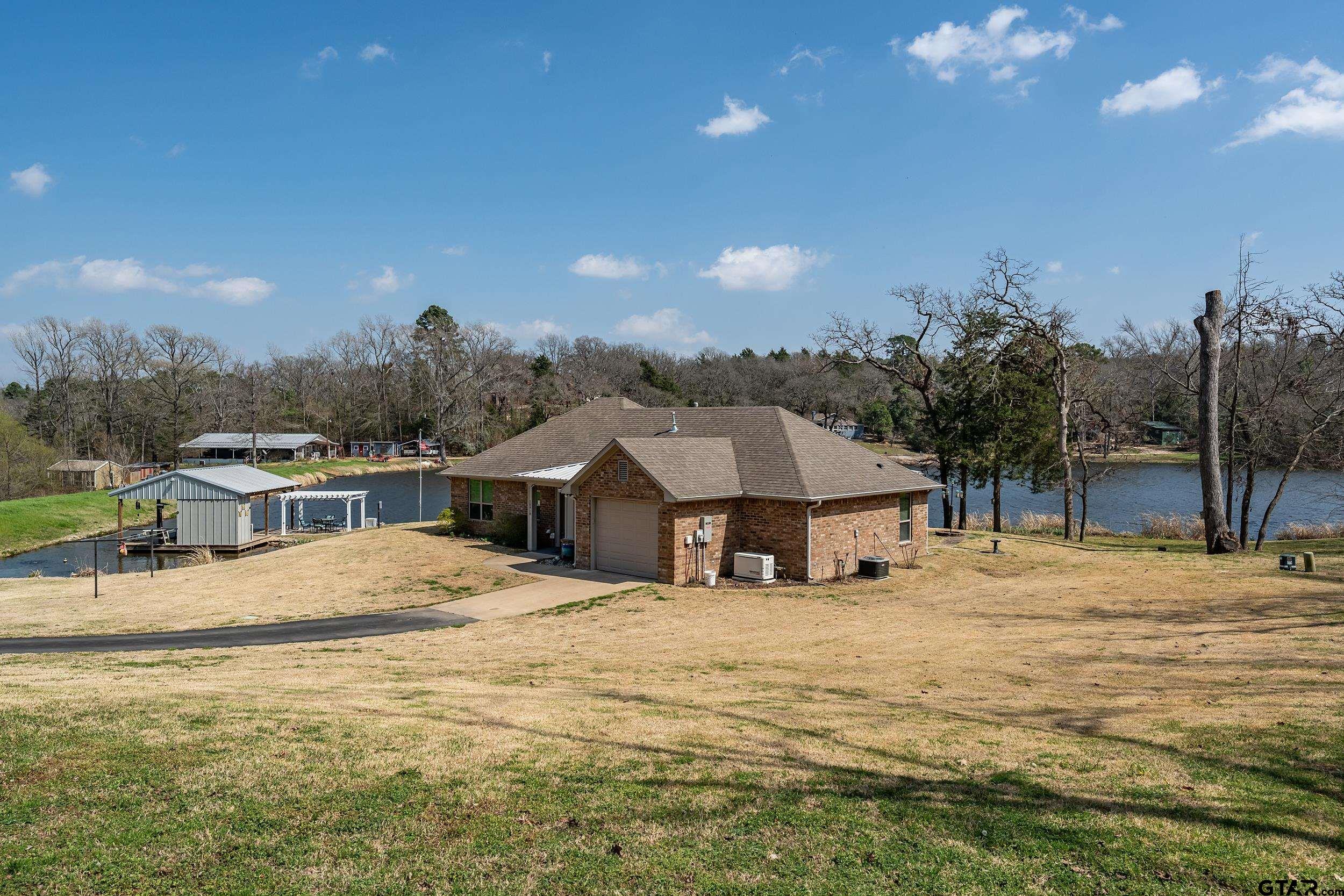 10918 Spring Club Lake Tyler, TX 75706 - Photo 2 of 23 a house with trees in front of it