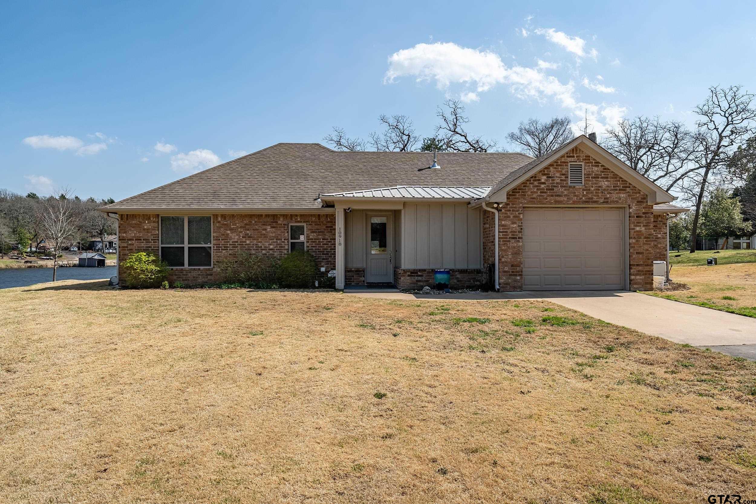 10918 Spring Club Lake Tyler, TX 75706 - Photo 3 of 23 a front view of a house with a yard and garage