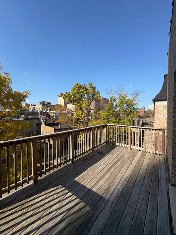 a view of balcony with wooden floor and fence