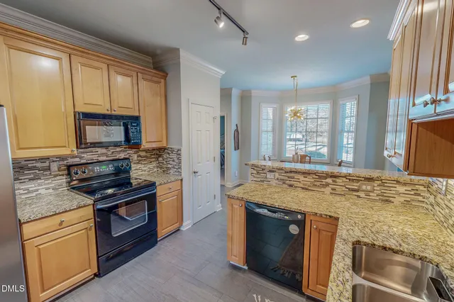 a kitchen with stainless steel appliances granite countertop a stove microwave and sink