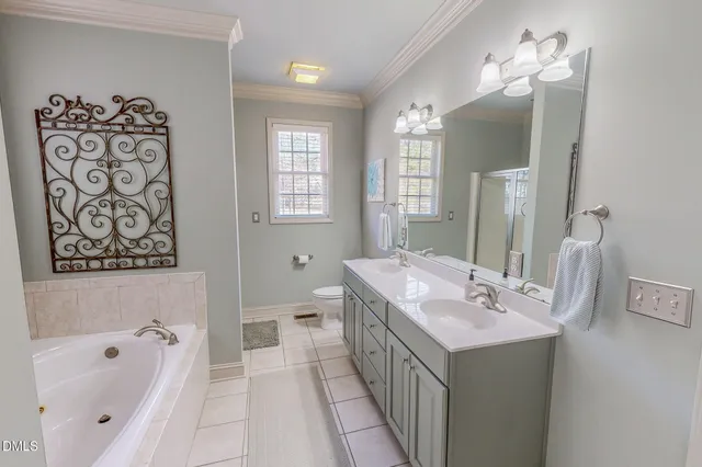 a spacious bathroom with a tub sink and mirror