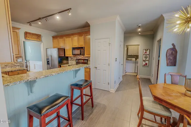 a hall with kitchen island stainless steel appliances furniture cabinets and a counter top space