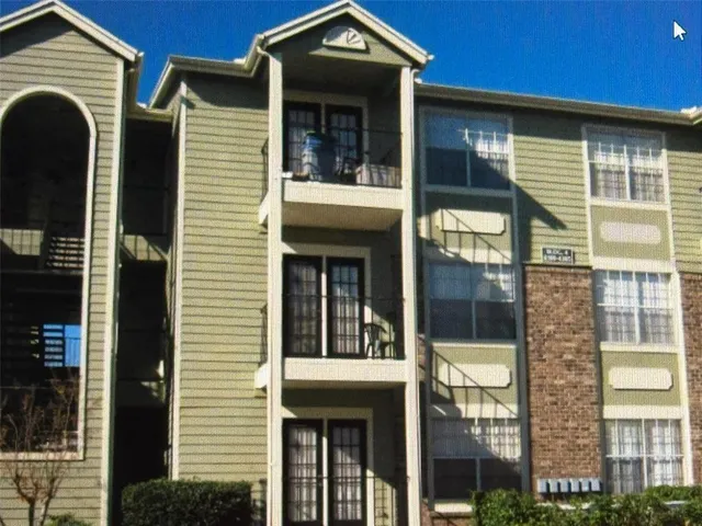 a view of a brick house with large windows