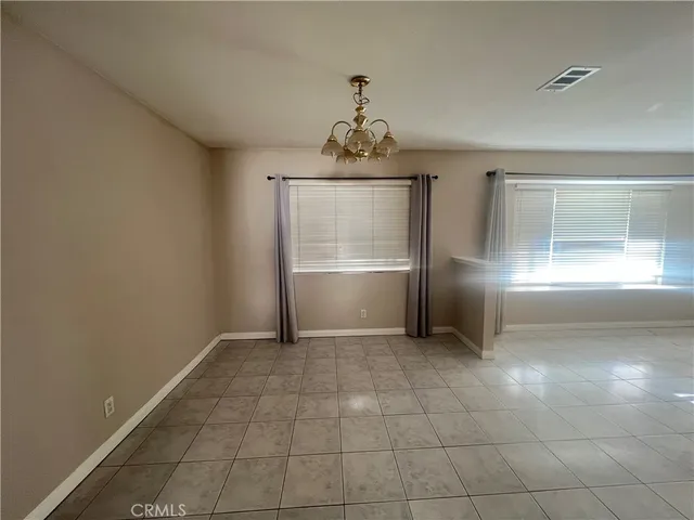 an empty room with windows and fireplace