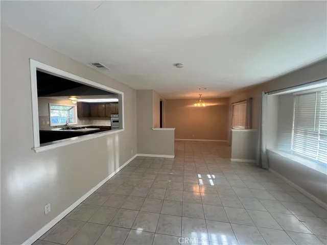 a view of a livingroom with wooden floor and kitchen space