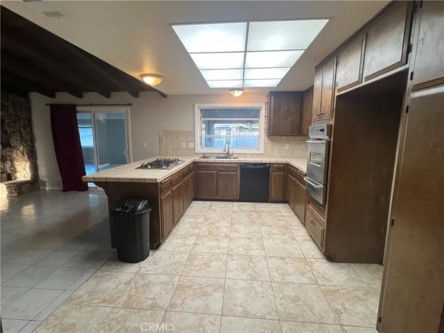 a kitchen with stainless steel appliances granite countertop a sink counter space and a window
