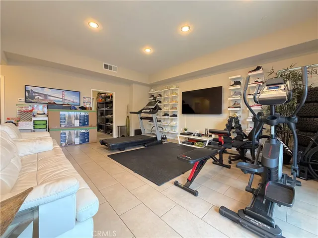 a room with gym equipment and a flat screen tv