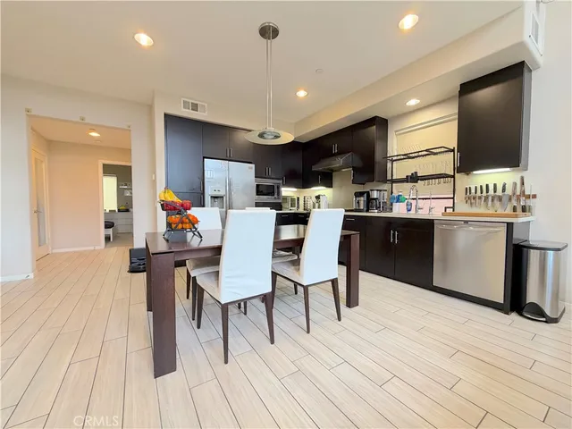 a dining room with kitchen island stainless steel appliances furniture a dining table and chairs