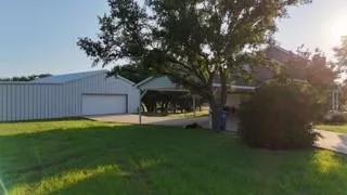 a view of a house with a yard and a tree