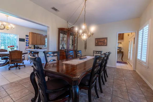 a kitchen with stainless steel appliances granite countertop a table chairs in it and a window